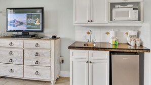Une cuisine moderne avec des meubles blancs, un four à micro-ondes encastré, un évier et un lave-vaisselle.