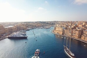 Un port où de nombreux yachts sont amarrés le long de la promenade, entouré de bâtiments historiques.
