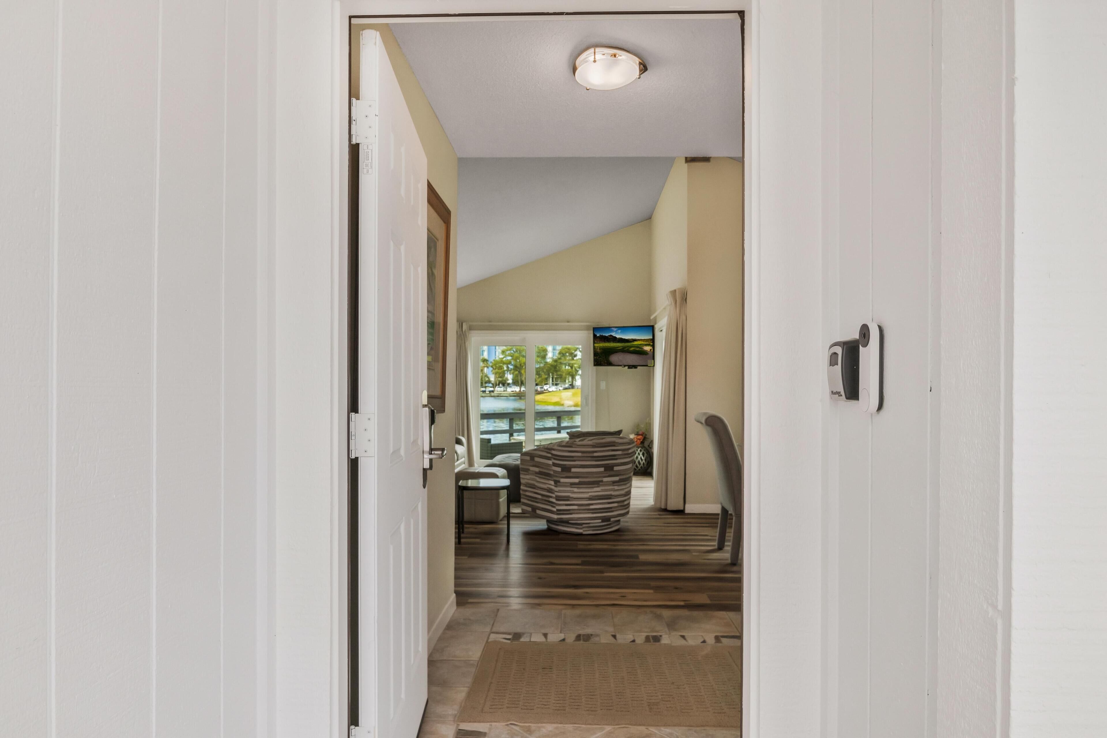 A hallway with a view into a living area, a fireplace, and a door leading to another room.