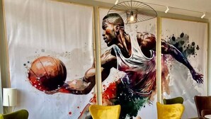 A modern lounge area with a large mural of a basketball player, comfortable seating, and a minimalist design. - Avo Sport Résidence, Diamniadio (Diamniadio)
