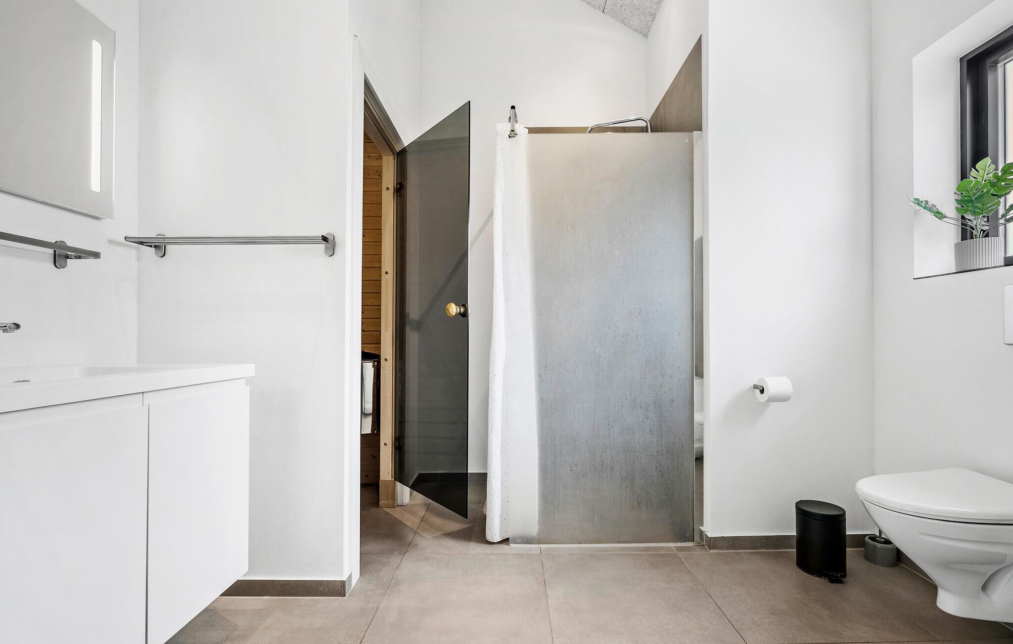 Une salle de bain moderne équipée de toilettes, d’une douche et d’un lavabo.