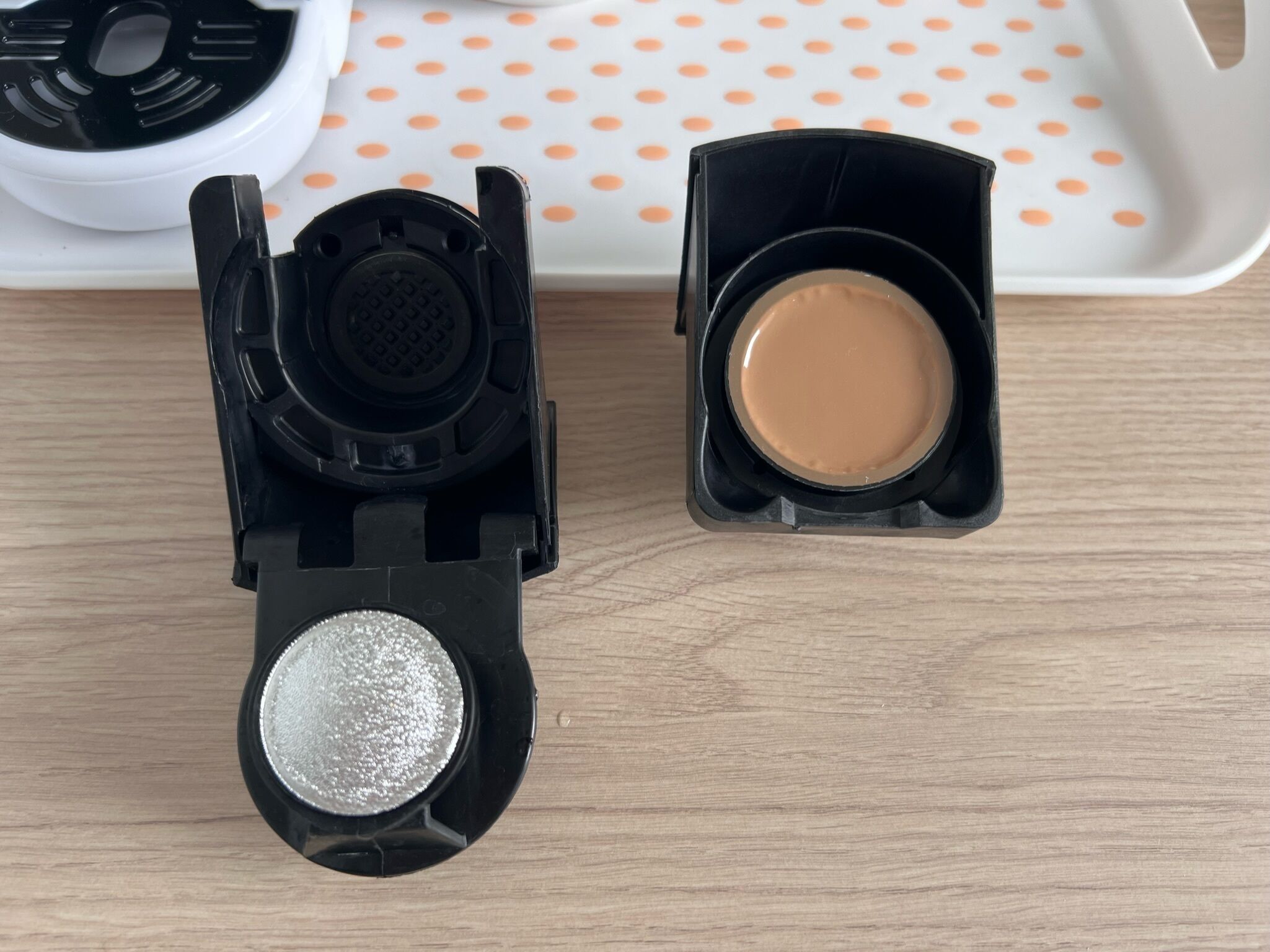 A makeup compact with a mirror and two shades of makeup.
