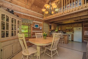 Cozy cabin interior with a dining area, kitchen, and living space.