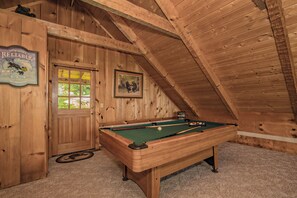 Relax in this inviting room with a pool table and cozy atmosphere.