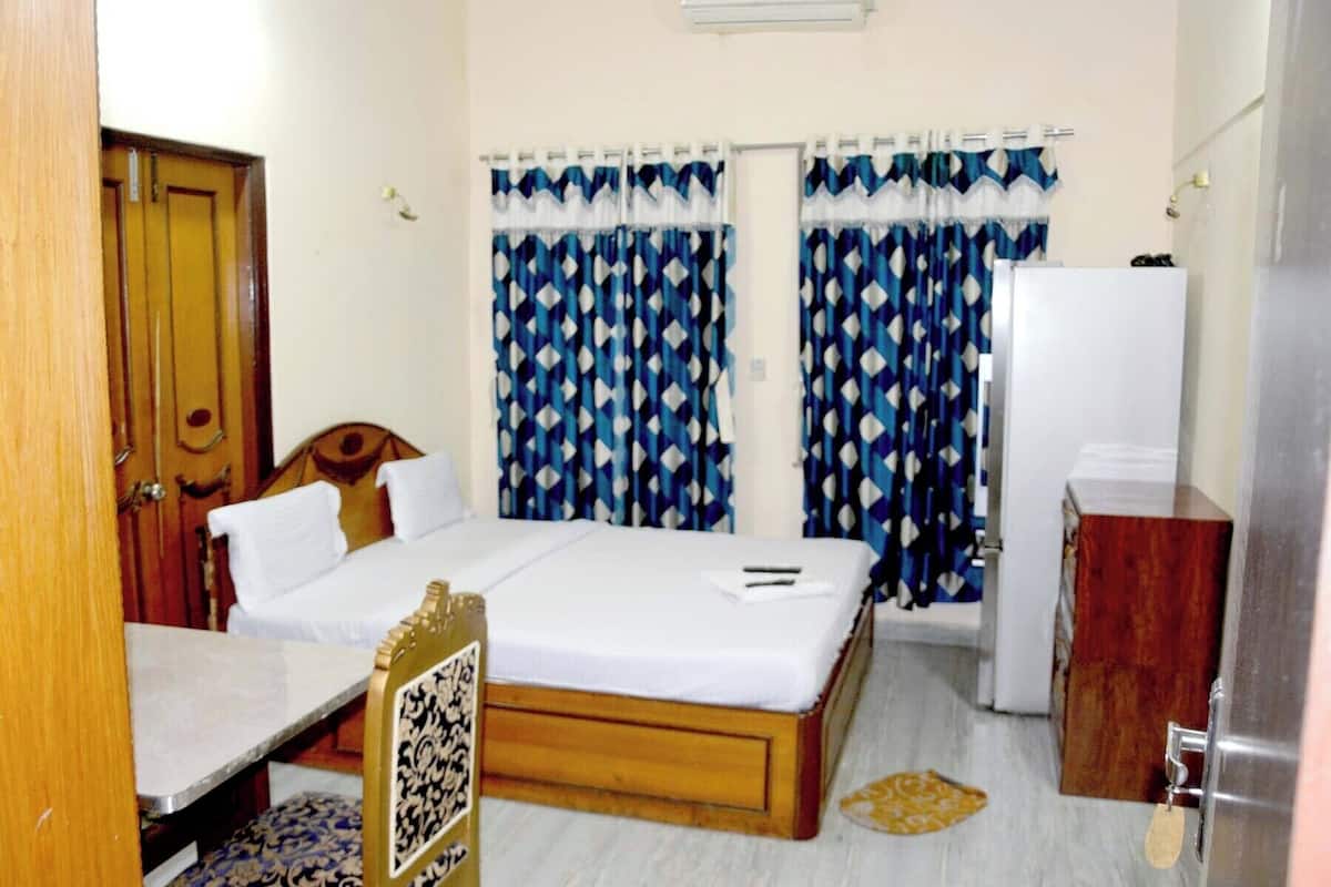 A room with a bed, a desk, a wardrobe, and curtains.
