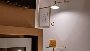 A modern interior with a fireplace, a framed picture of the word 'LOVE', and a minimalist lamp. - Elegant Suite in the heart of Naples  (Napoli)