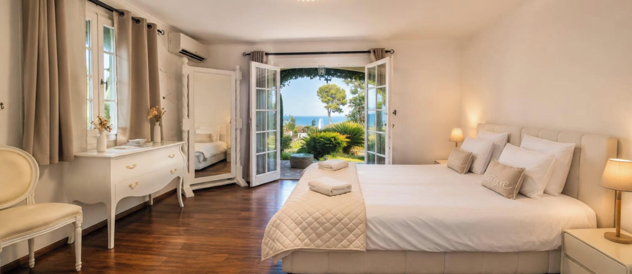 Une chambre d’hôtel avec un lit, une table de chevet, une lampe et une vue sur l’extérieur.