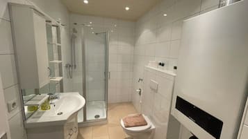 Standaard appartement | Badkamer | Een douche, een haardroger, handdoeken