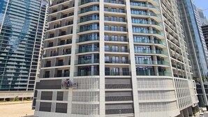 A multi-story hotel with a curved facade, large windows, and a modern architectural design. - Relax in Style Central 1BDR Cityscape (Dubai)
