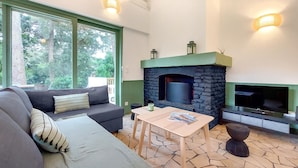 A cozy living room with a stone fireplace, a sofa, a coffee table, and a TV. - Gorgeous home in Lege-Cap-Ferret with WiFi (Lege-Cap-Ferret)