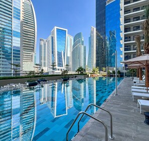 Una piscina con vistas a altos edificios modernos al fondo.