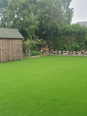 A well-maintained grassy yard with a wooden shed and a stone wall. - 3BR Detached Bungalow w/Parking
(Sheffield)