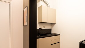 A compact kitchen with a black sink, beige cabinets, and a small countertop. - Loft 404 by Wonderful Italy (Bari)