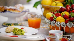 Colazione con dolci, frutta e un bicchiere di succo d'arancia.