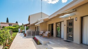 A modern house with a covered patio, outdoor seating, and a garden. - Phos Elegant Residences by Konnect, 400m to the beach (Corfu)