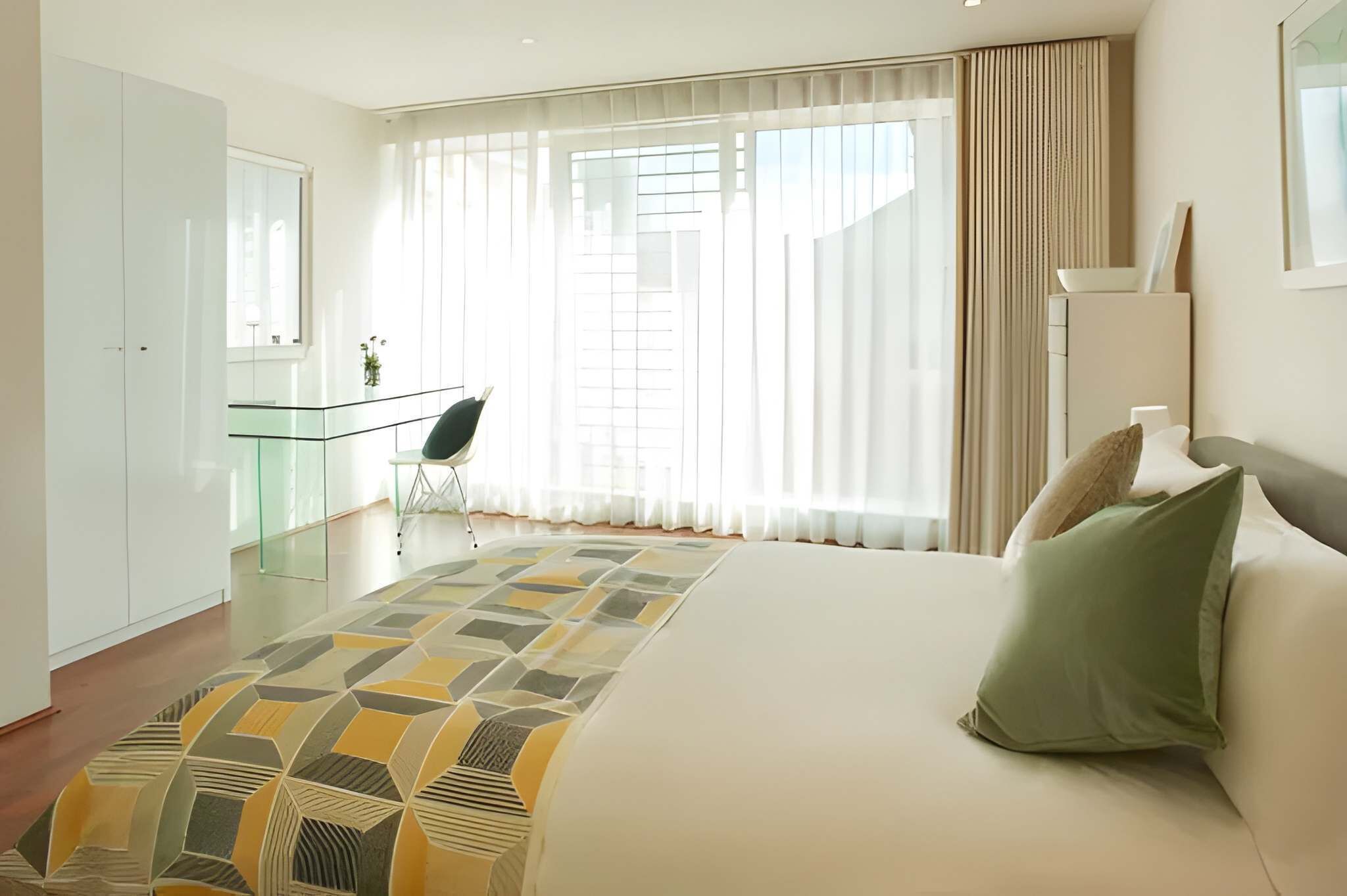 Une chambre d’hôtel avec un lit, un bureau et une chaise.