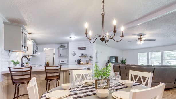 A modern kitchen with white cabinets, a dining area with a round table, and a ceiling fan. - North Fairfield Family Home w/ Hot Tub & Porch! (North Fairfield)