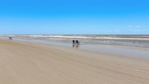 A beach with two chairs and an umbrella. - Steps to Crystal Beach! Family & Pet-friendly Home (Port Bolivar)