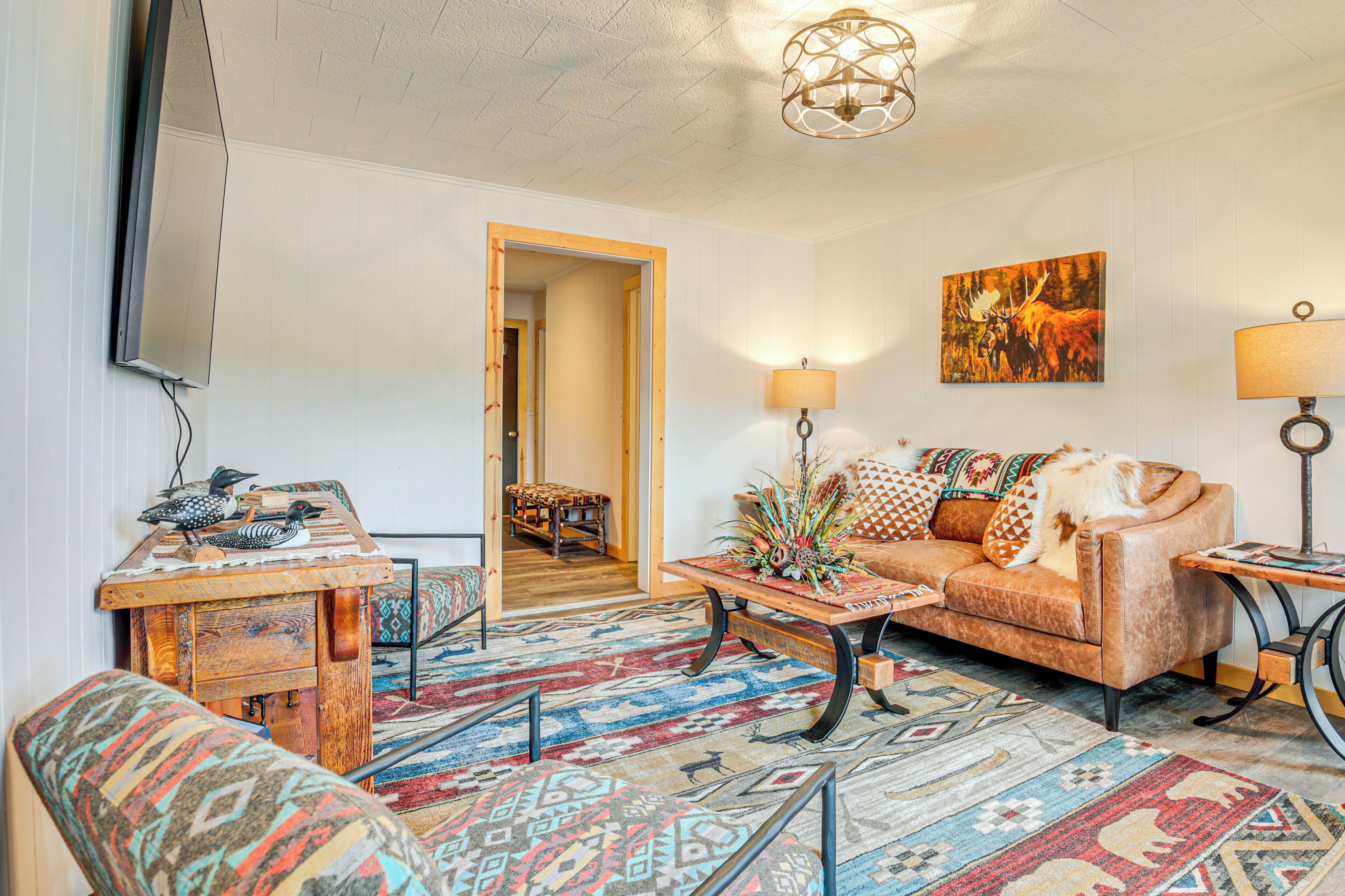 A cozy living room with a sofa, coffee table, and patterned rugs.