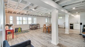 A spacious room with a high ceiling, exposed beams, and large windows. - Charming Wolcott Cottage w/ Fire Pit & Mini Dock (Wolcott)