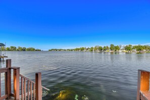 A calm lake with a wooden dock and a clear blue sky. - Charming Wolcott Cottage w/ Fire Pit & Mini Dock (Wolcott)