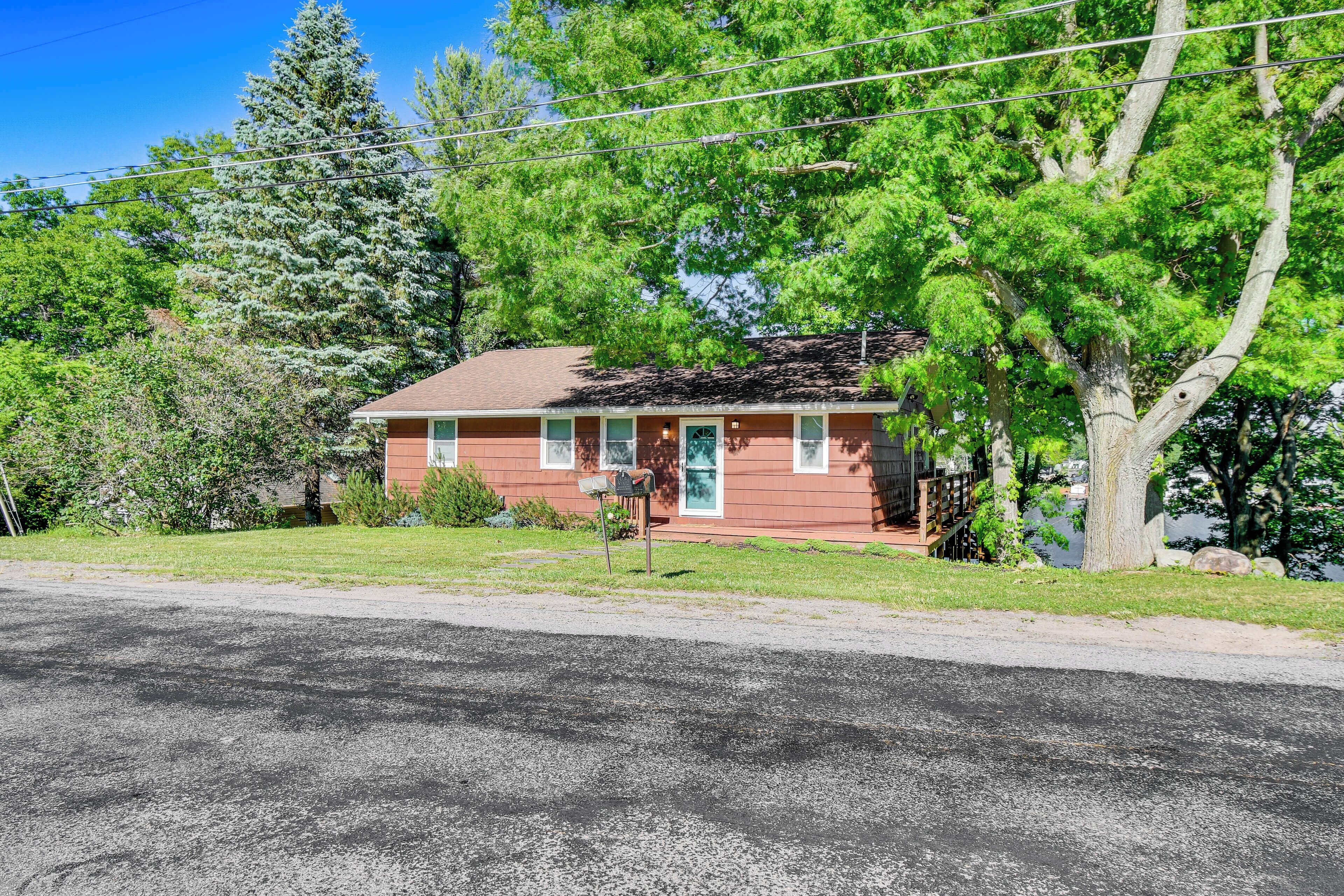 A single-story house with a red exterior, a front porch, and a mailbox.