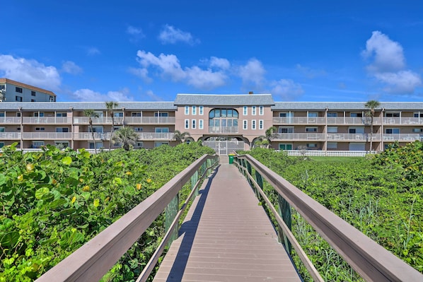 A hotel with a central courtyard, multiple balconies, and a wooden walkway.