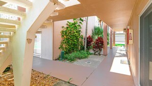 Une galerie couverte dotée d’un sol en béton, entourée d’immeubles à la façade beige.