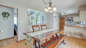 A dining area with a wooden table, benches, and chairs. There is a kitchen area with a microwave and cabinets. - Walk to Park: Waterloo Home w/ Furnished Deck (Waterloo)