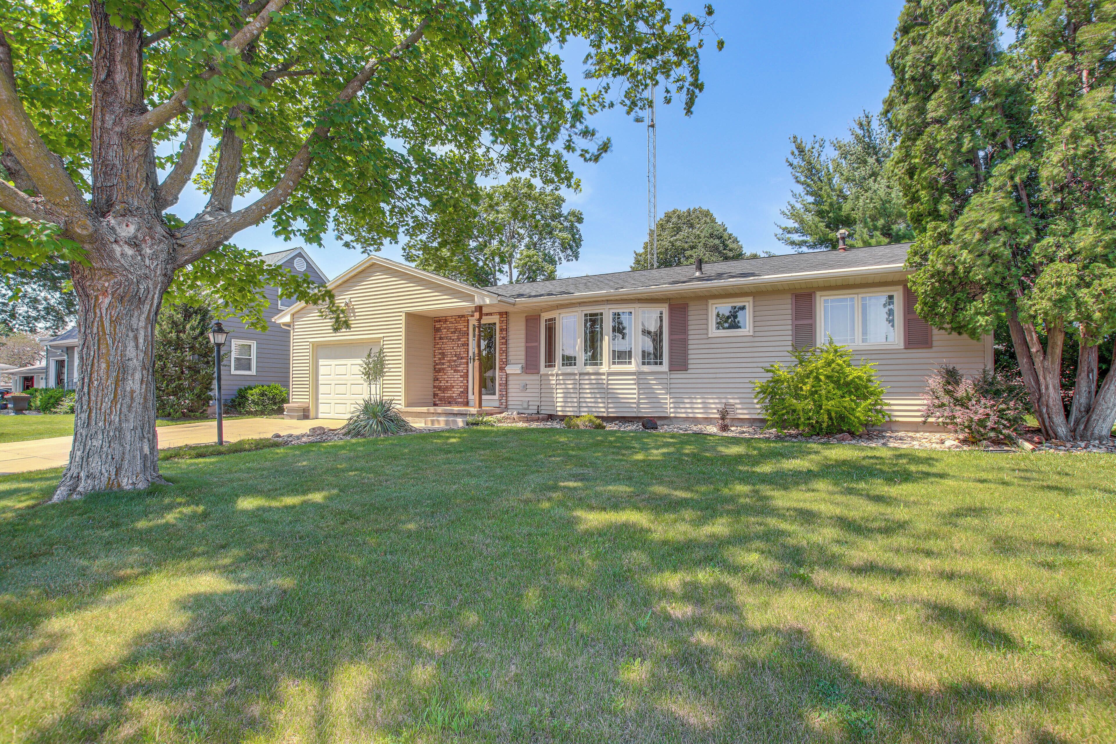 A single-story house with a front porch, a brick chimney, and a well-maintained lawn.