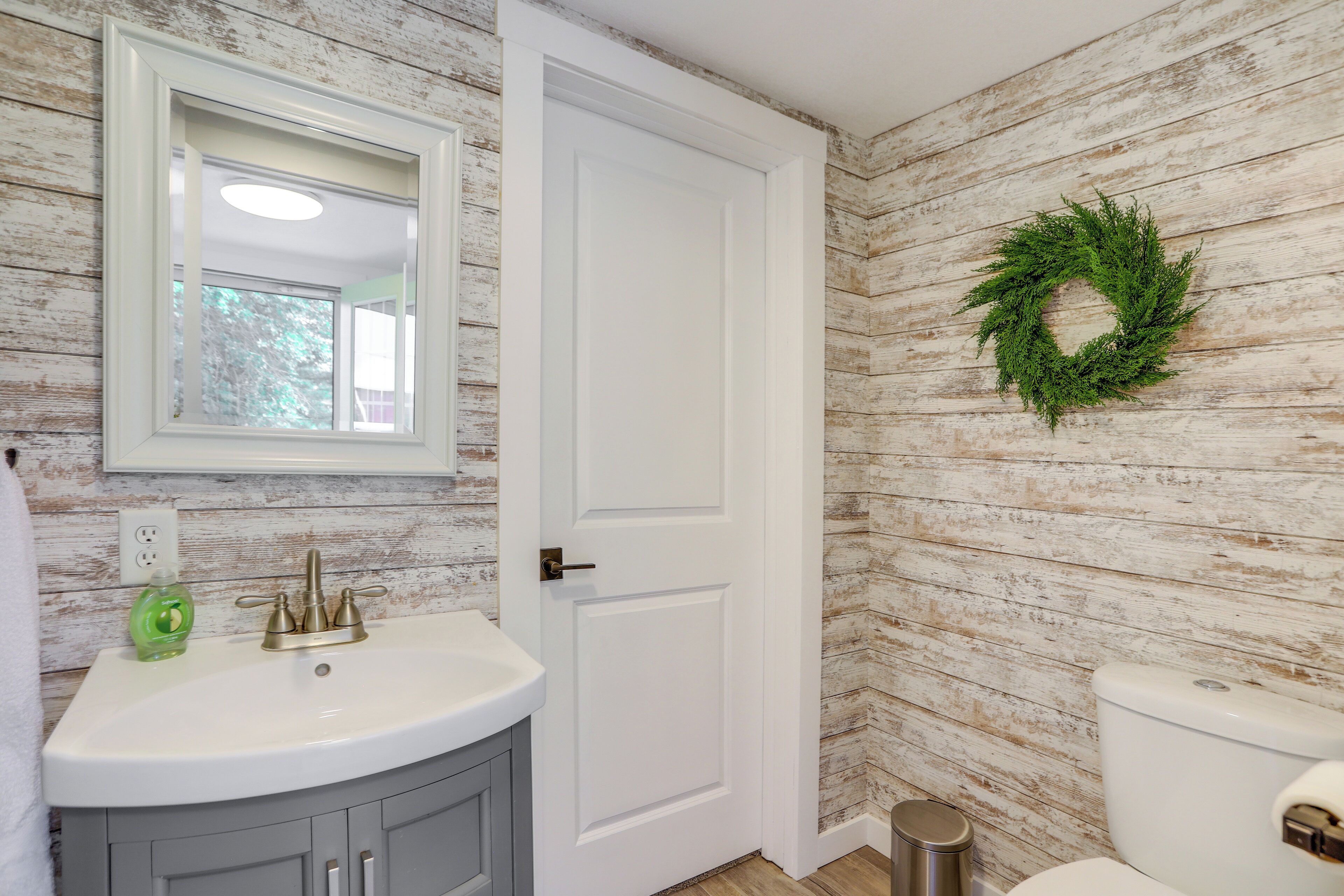 Un baño con un lavabo blanco, un espejo y un inodoro.