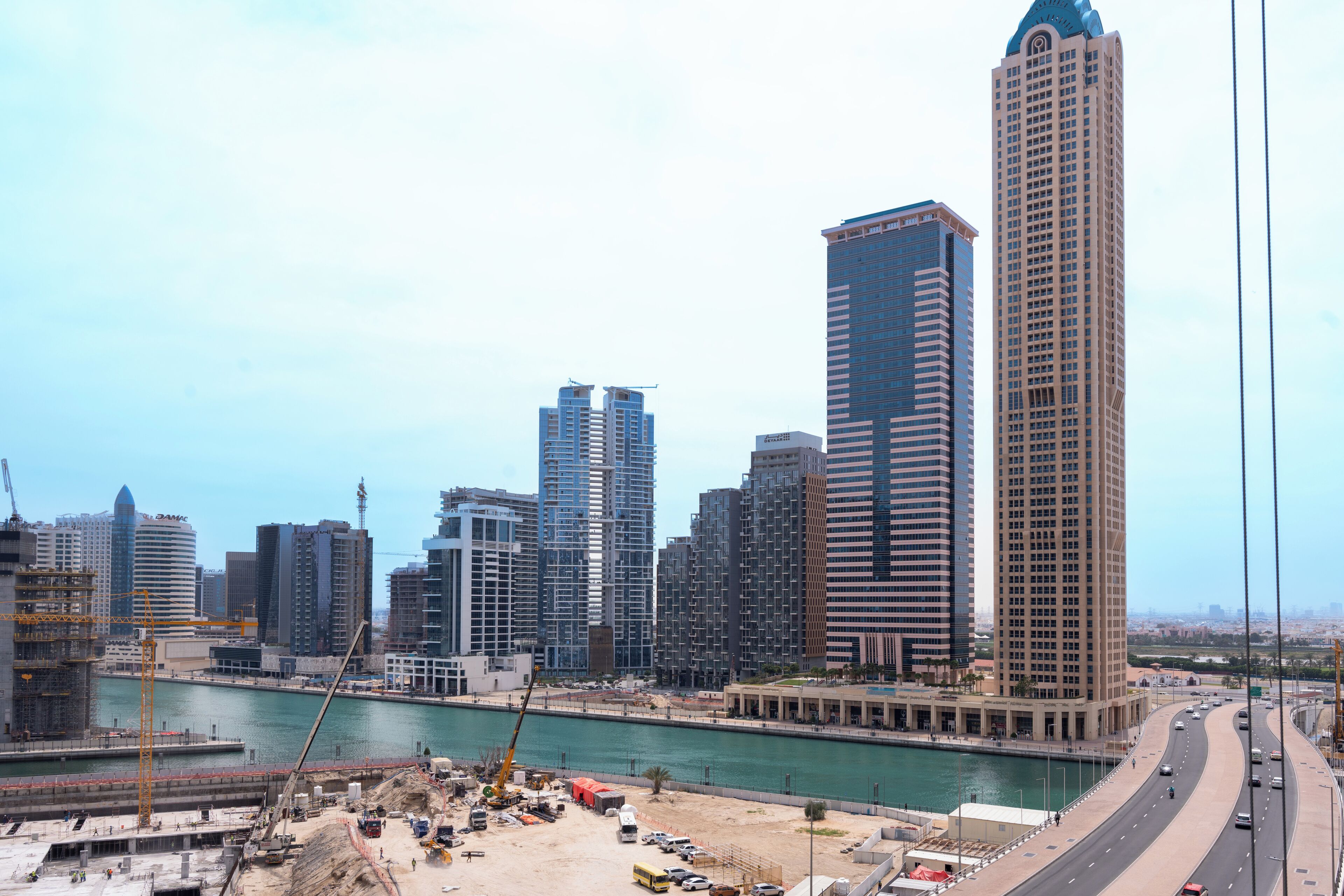 A cityscape with high-rise buildings, a river, and a highway.
