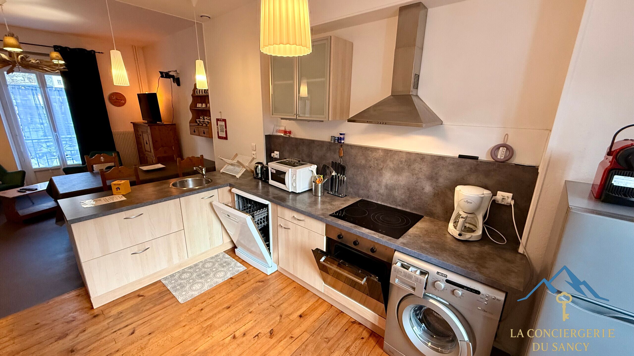 A modern kitchen with a built-in dishwasher, oven, and washing machine.