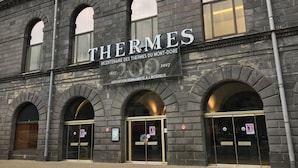 A building with the name 'THERMES' and a sign indicating a bicentennial event.