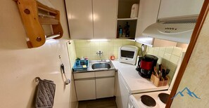 A compact kitchen with a sink, microwave, coffee maker, and stove. - Le Pradet A 781 - Mont Dore 4 pers (Mont-Dore)