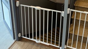 Eine Treppe mit weißer Geländer, Holzstufen und einem Bild an der Wand.