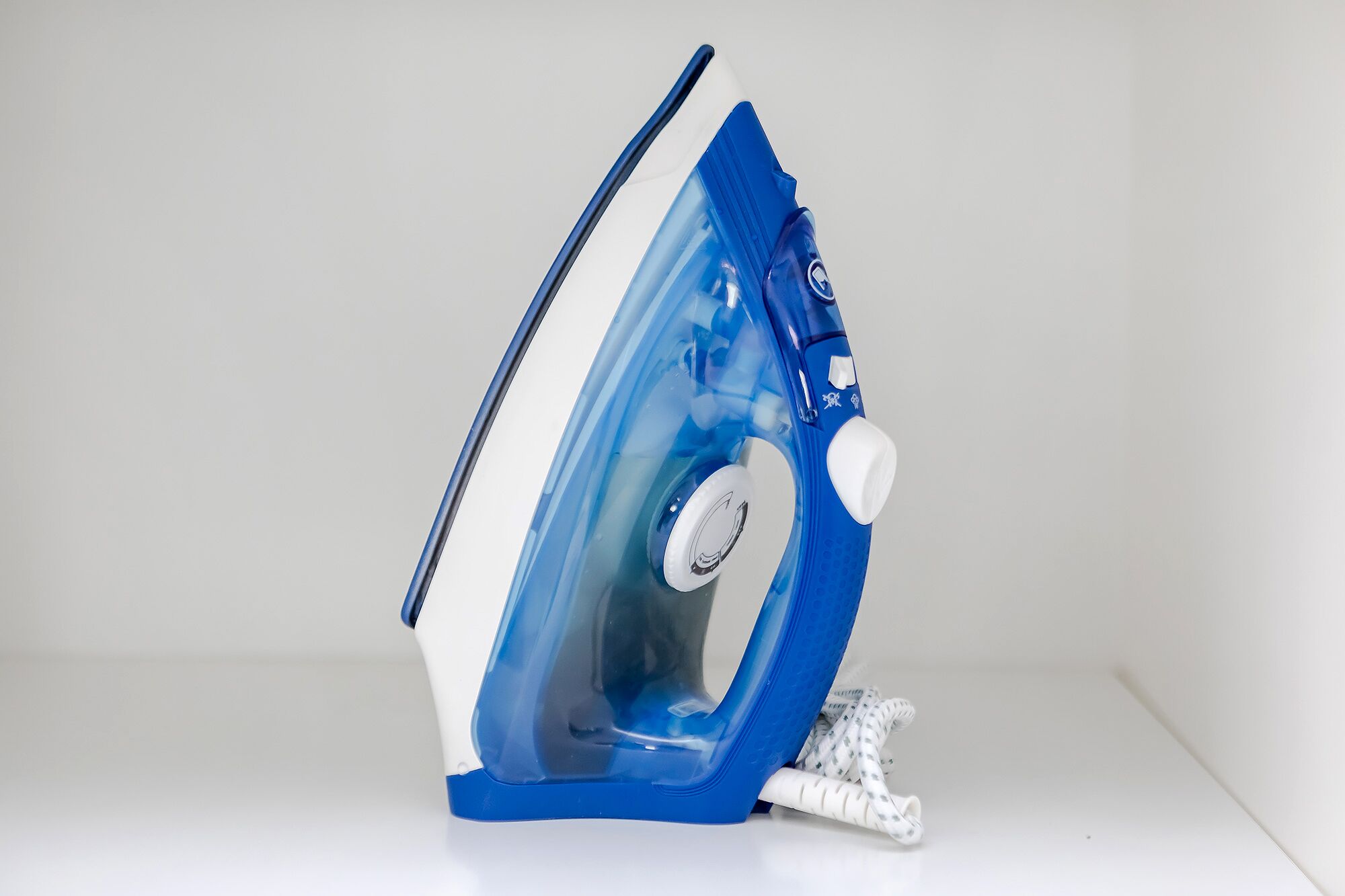 Un cepillo para la ropa azul y blanco con cable conectado.
