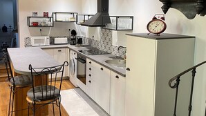 Une cuisine moderne dotée d’un îlot central, de planchers en bois et d’une cuisinière intégrée.