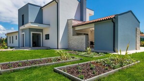 A modern two-story house with a well-maintained lawn and garden beds. - Villa Jan in Valbandon (Valbandon)
