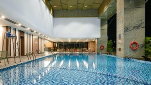 An indoor swimming pool with a tiled floor, a wooden ceiling, and a marble wall. - Wyndham Garden Legend Halong (Bai Chay)