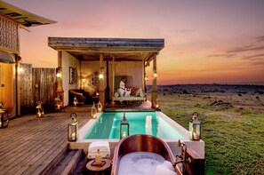 A wooden deck with a pool, a hot tub, and a seating area with a view of the horizon. - One Nature Mara River (Serengeti)