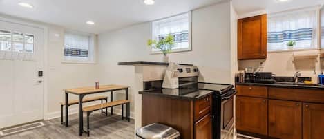 Uma cozinha moderna com bancada de madeira, eletrodomésticos de aço inoxidável e um banco.