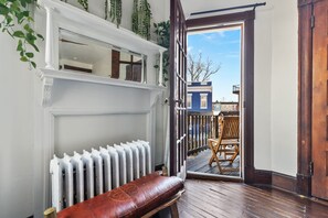 Une pièce avec un banc en bois, un radiateur et une vue sur l’extérieur.