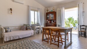 Ein gemütliches Zimmer mit einem Bett, einem Holztisch mit Stühlen, einem Schrank und Blick ins Freie.