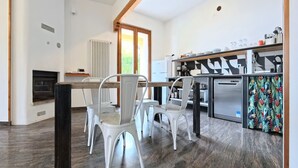 Une cuisine moderne avec des chaises blanches, une table à manger et une vue sur l’extérieur.