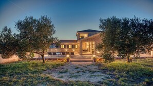 A two-story house with a stone facade, a covered patio with outdoor seating, and a well-maintained lawn. - Luxury Villa Oliva Oliana heated pool 32m2, bbq, family (Vrsi)