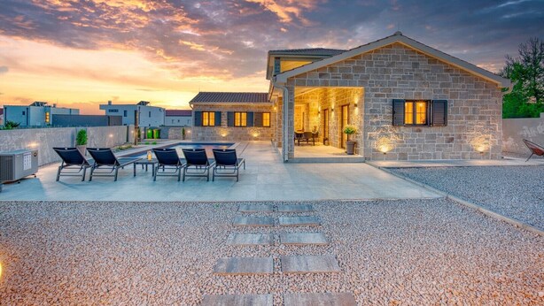 A stone building with a patio area, outdoor seating, and a view of the sunset. - Luxury Villa Oliva Oliana heated pool 32m2, bbq, family (Vrsi)