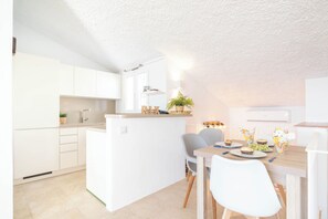 Enjoy meals in the kitchen with a central island and dining area featuring a wooden table and chairs.