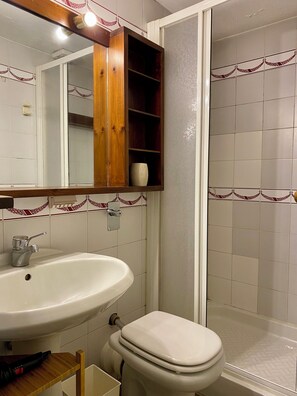 A bathroom with a white sink, wooden cabinet, and a toilet. - Art Flat- Stendhal 30 (Milan)