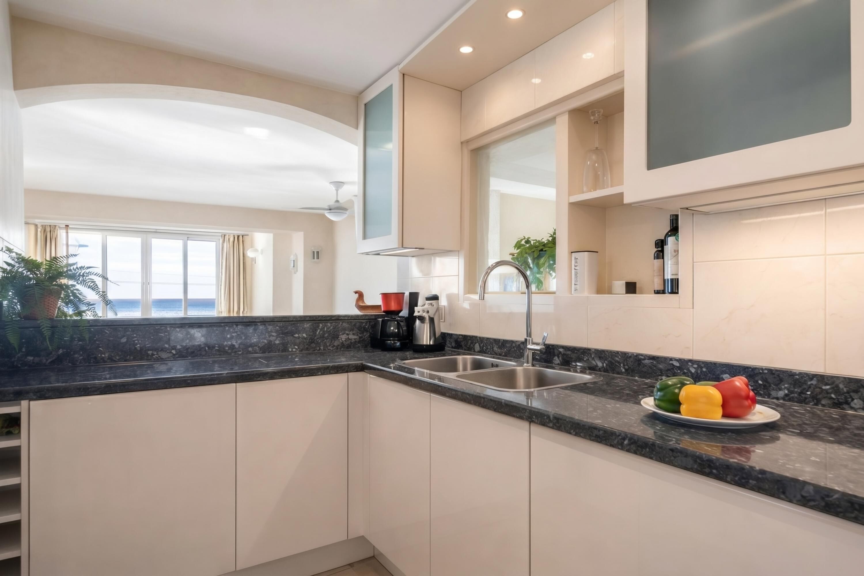 A modern kitchen with a large window, a built-in oven, and a sink.